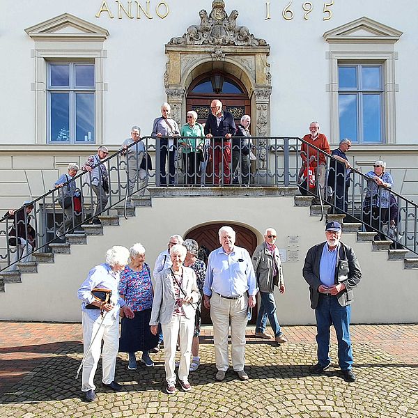Die Ausflugsgruppe des Seniorenrates steht vor der Treppe des Historischen Rathauses.
