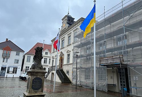 Die Nationalflagge der Ukraine weht vor dem Historischen Rathaus.