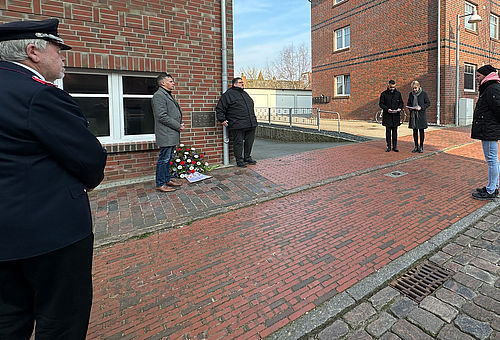 Eine Gruppe Personen gedenkt in der Schützenstraße der Opfer der Gasexplosion