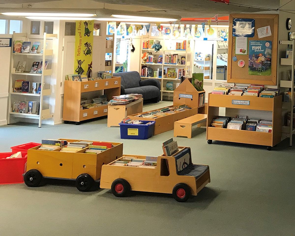 Ein Spielzeugauto aus Holz steht in der Kinderabteilung der Stadtbibliothek.